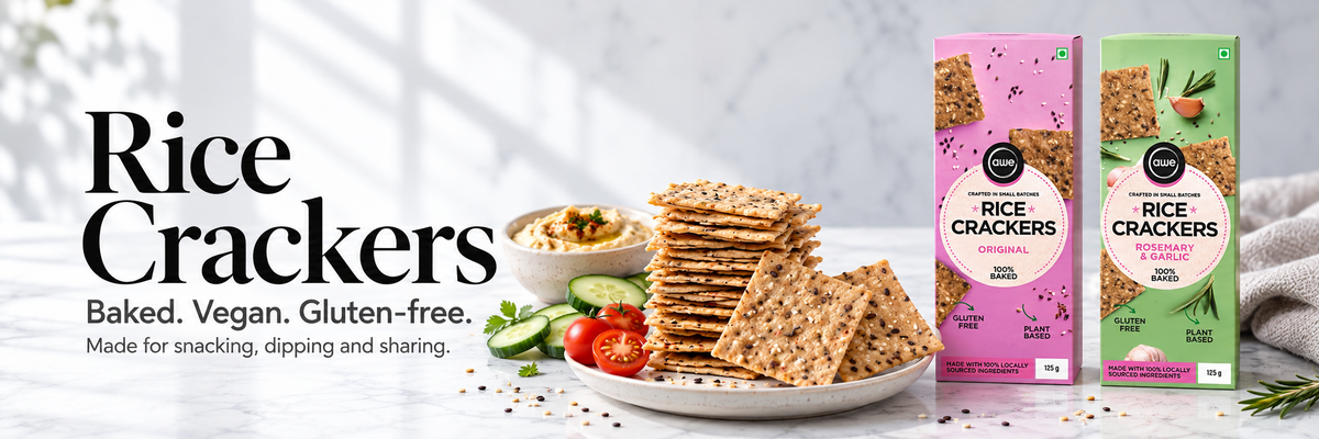 AWE Foods Original and Rosemary & Garlic rice cracker boxes beside crackers, hummus, cucumber and tomatoes.