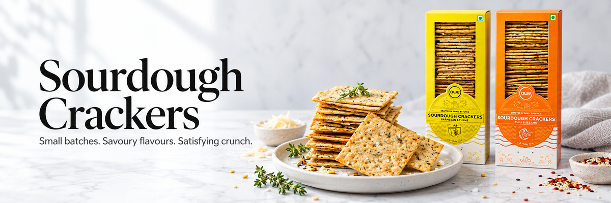 Golden square AWE Foods sourdough crackers stacked against a light background